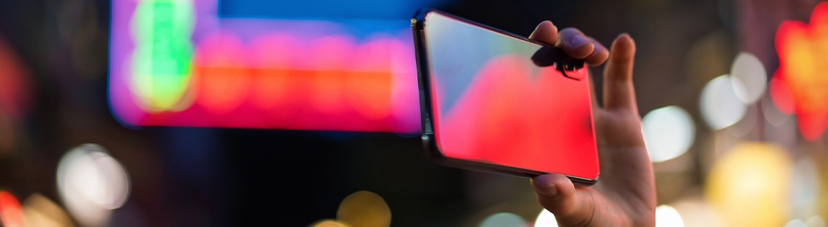 Individual on their mobile device researching audience measurement solutions relevant to digital measurement.